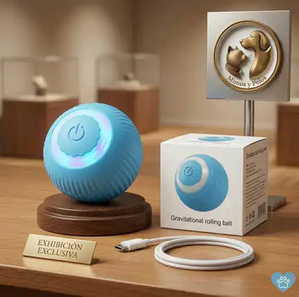 Pelota inteligente interactiva para gatos Mimos y Pelos sobre base de madera con su caja y cable de carga
